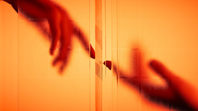 Hands touch behind frosted glass in warm light
