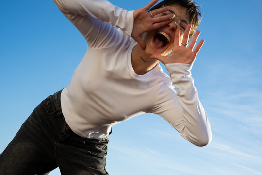 Woman in long-sleeved T-shirt shouting with joy.