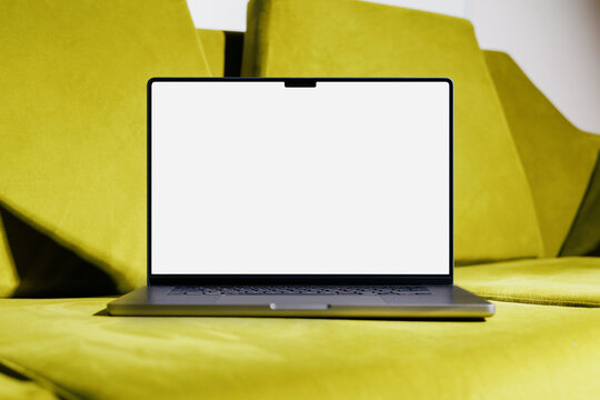 laptop mockup with blank white screen on green sofa