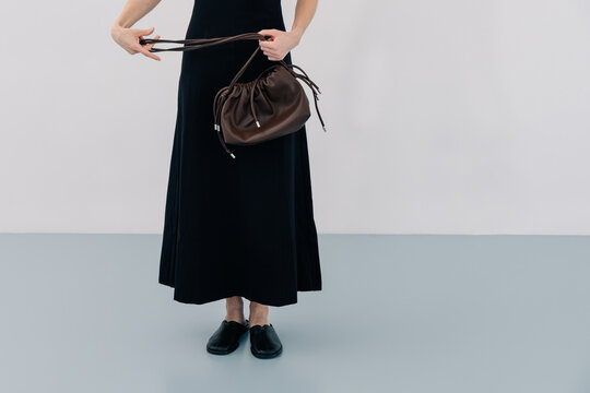 Minimal fashion look with black dress and leather bag