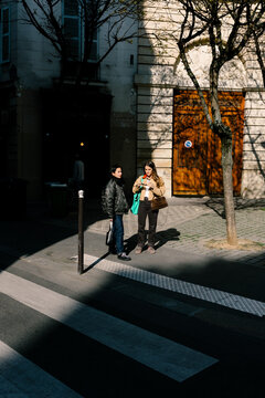A wide shot of two friends chatting on the streets of Paris