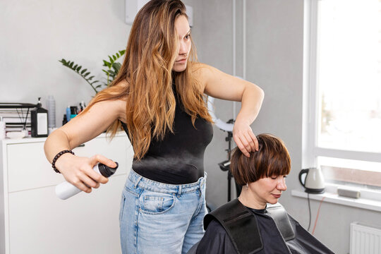 The hairdresser is styling hair.