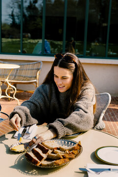 Woman having breakfast at a rural French hotel terrace