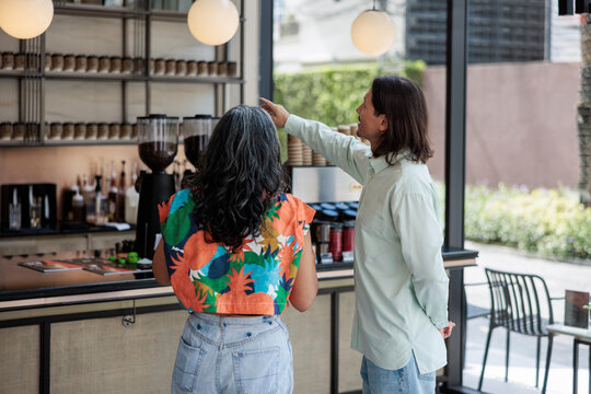 Couple choosing drinks together at cafe counter
