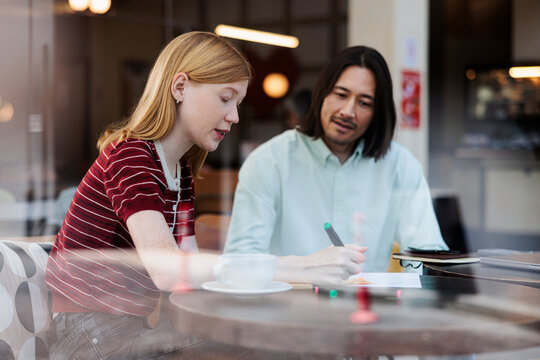 Two people collaborating at a cafe table.