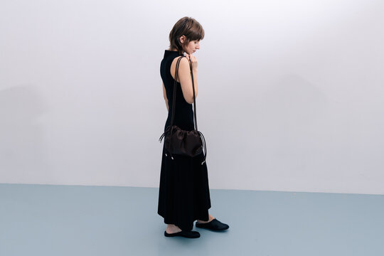 Minimal fashion full body woman with leather bag in studio