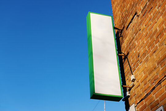 Signboard Mounted on Brick Wall Under Clear Sky