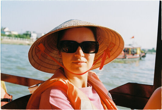 Tourist enjoying a boat ride wearing a sun hat in a Mekong river 