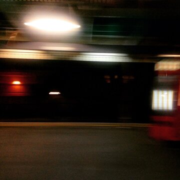 Motion blurred view of a train station platform at night