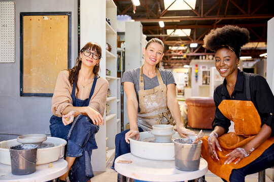 Portrait of three friends in a ceramics workshop