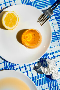 Summer picnic still life with jelly dessert, lemon and messy table.