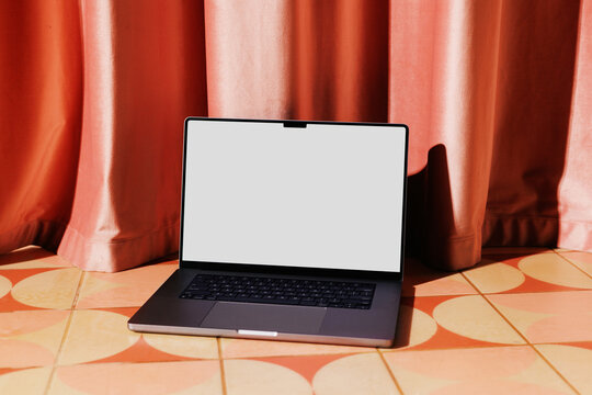 Business laptop white screen mockup on patterned floor