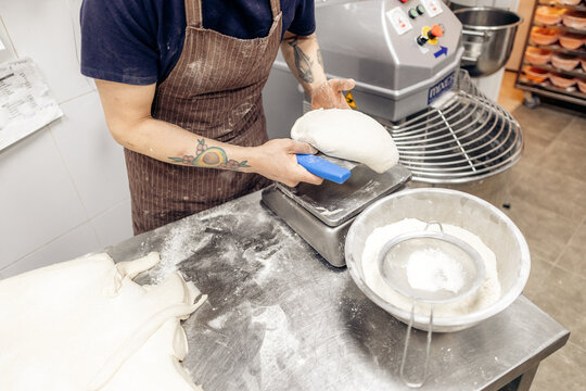 Baker weighing dough on digital scale