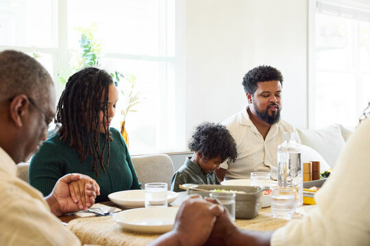 Family Prays Together Before Sharing a Meal