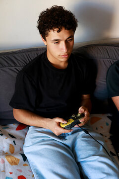 Young Person Playing Video Game on Couch During Daytime