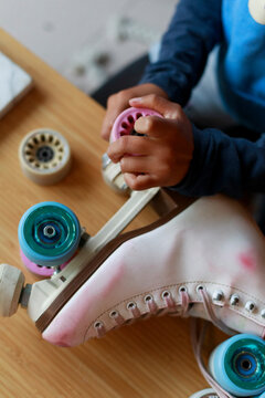 Hands Work on Roller Skate Wheels During a Repair Session