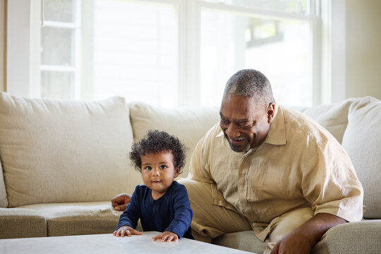 Grandfather Plays With Grandson at Home on Sofa