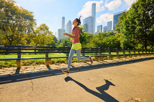 Woman sprints through a vibrant park in New York City