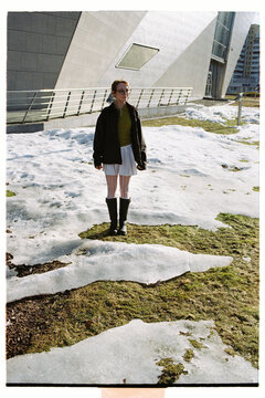 Standing on melting snow in a city park during early spring