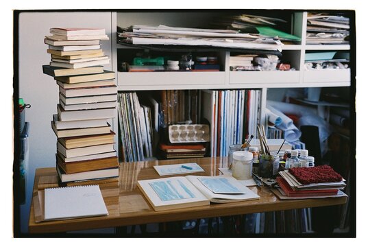 Books and art supplies on a work desk
