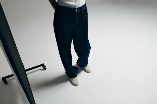 Person modeling comfortable dark denim jeans and sneakers