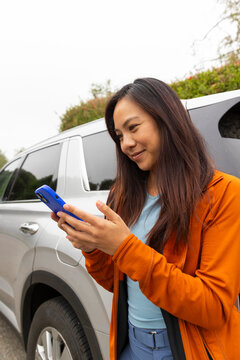 Confident Asian woman texting mobile phone Portrait 