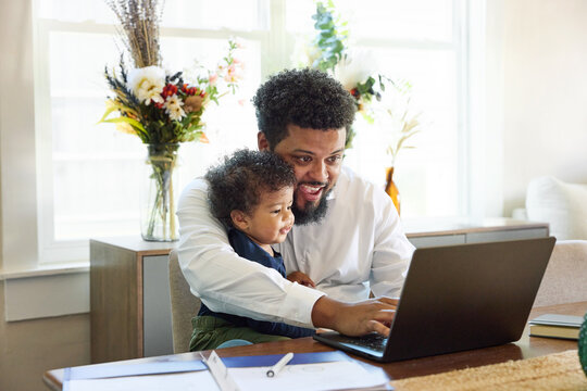 Father work from home with his little son