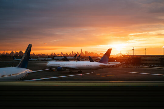 Airplanes at Newark Airport with New York City skyline during sunrise