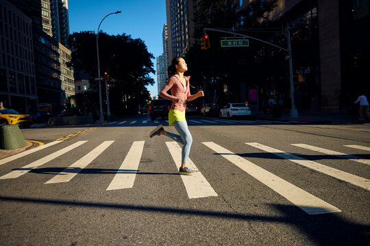 Sportswoman runs across the street in NYC