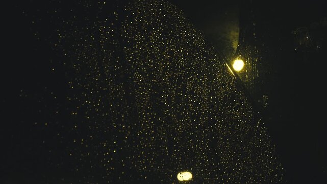 Raindrops on car windshield at night