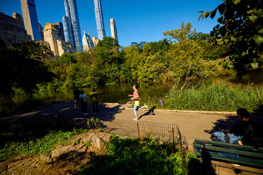 Woman runs in crowded Central Park.