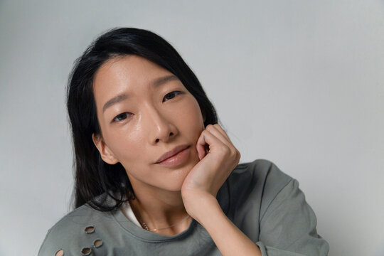 Person contemplating with hand on chin in studio