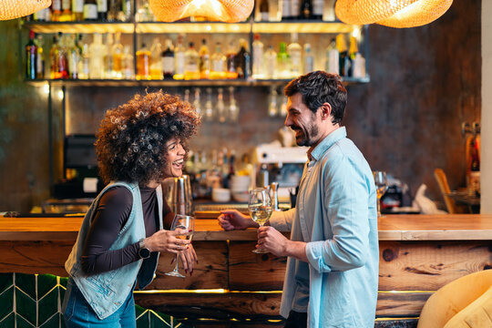 Happy couple enjoying drinks and conversation at bar counter