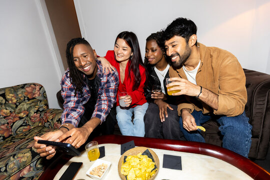 Group of Friends hanging out at home party checking smartphone