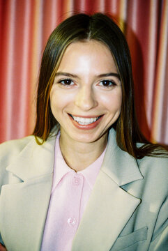 Portrait of a smiling business woman with curtain backdrop film photo