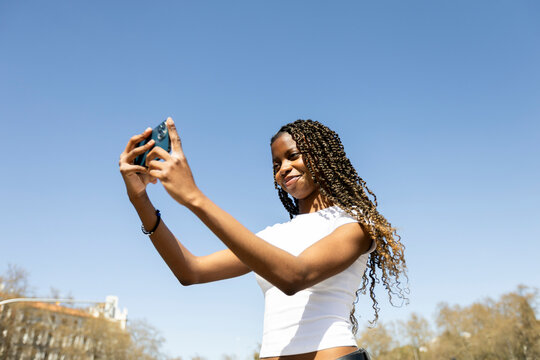 Woman using smartphone over blue sky