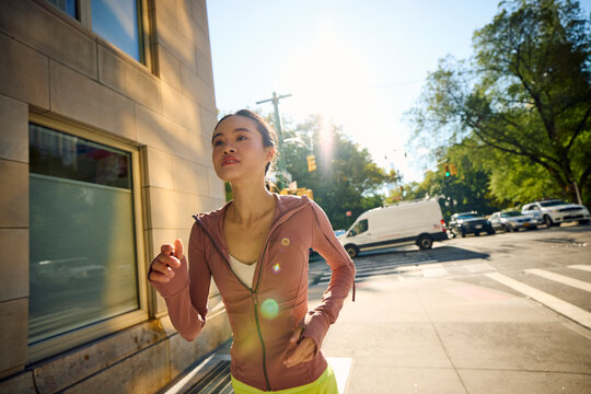 Active woman jogs on the NYC sidewalk for fitness