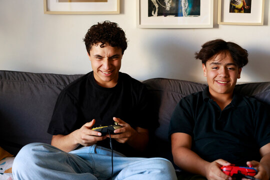 Friends Play Video Games on a Couch 