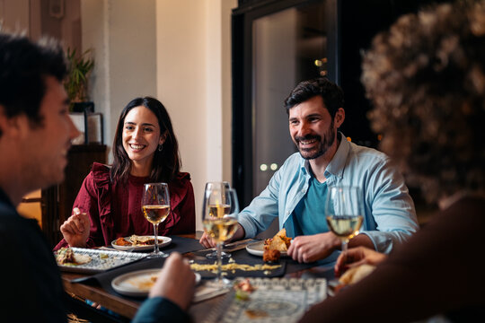 Friends sharing dinner, enjoying conversation in restaurant