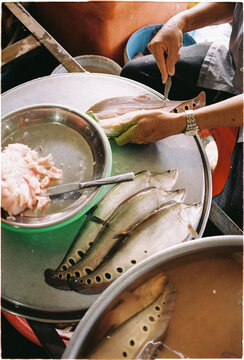 Fish preparation at a market, vendor working on fresh catch