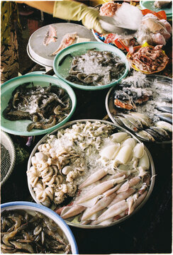 Seafood displayed on trays at a market during the morning hours