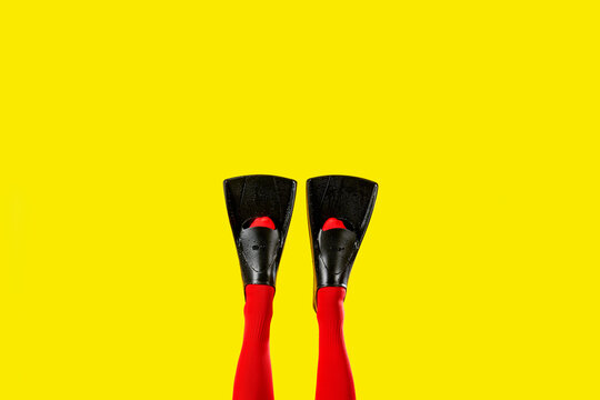 the legs of a man rise in red socks with diving fins