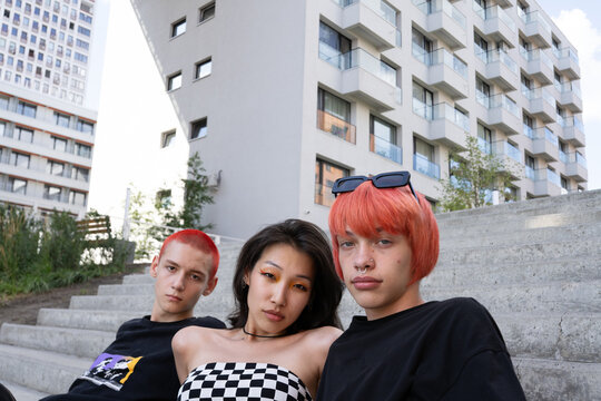 Stylish friends sitting on street