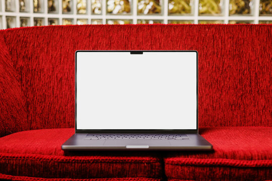 Laptop mockup with white screen on red sofa