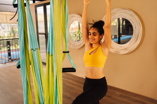A Woman Performs Aerial Yoga in a Studio