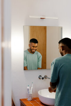 Motivated man in a home bathroom preparing for a remote workday