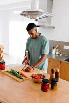 Stepping away from remote work, a man heads into the kitchen to cook
