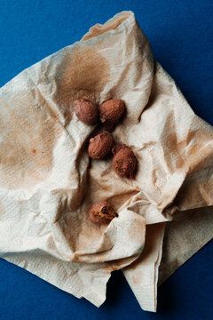 leftover olive pits lie on a creased paper napkin