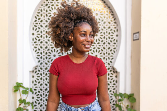 Portrait of a young black woman with afro hair and braces