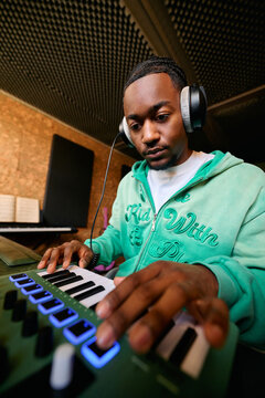 Music Producer Creating Music on MIDI Keyboard Controller Home Studio
